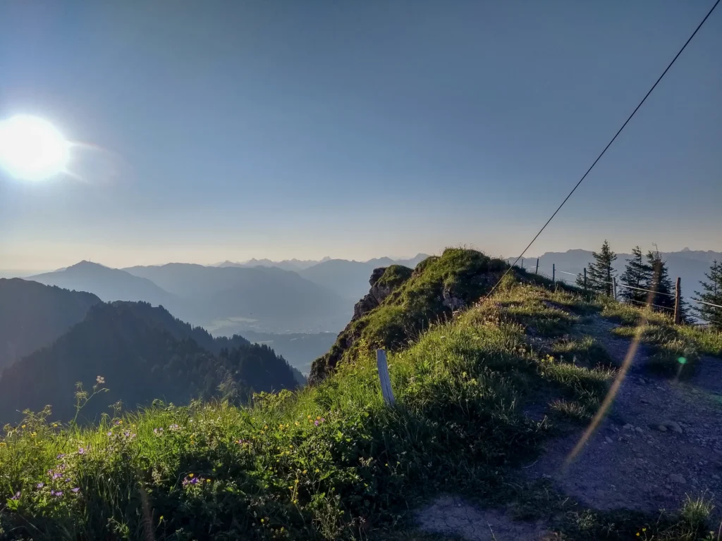Bergpfad im warmen Dämmerungslicht mit weitem Blick über das Oberallgäu